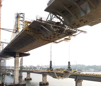 Bridge segments being installed above a river